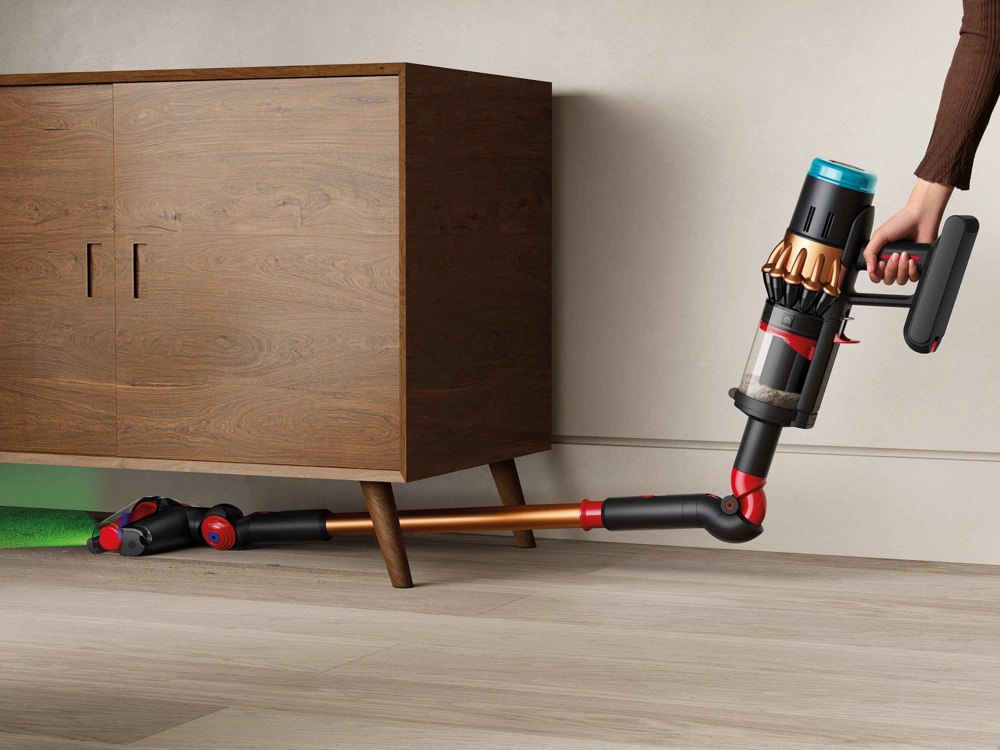 The Dyson V16 Piston Animal vacuuming under a cupboard.