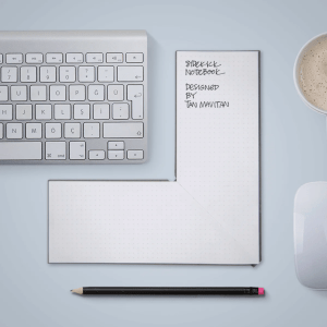 Keyboard with L-shaped notebook next to di and a pen below.