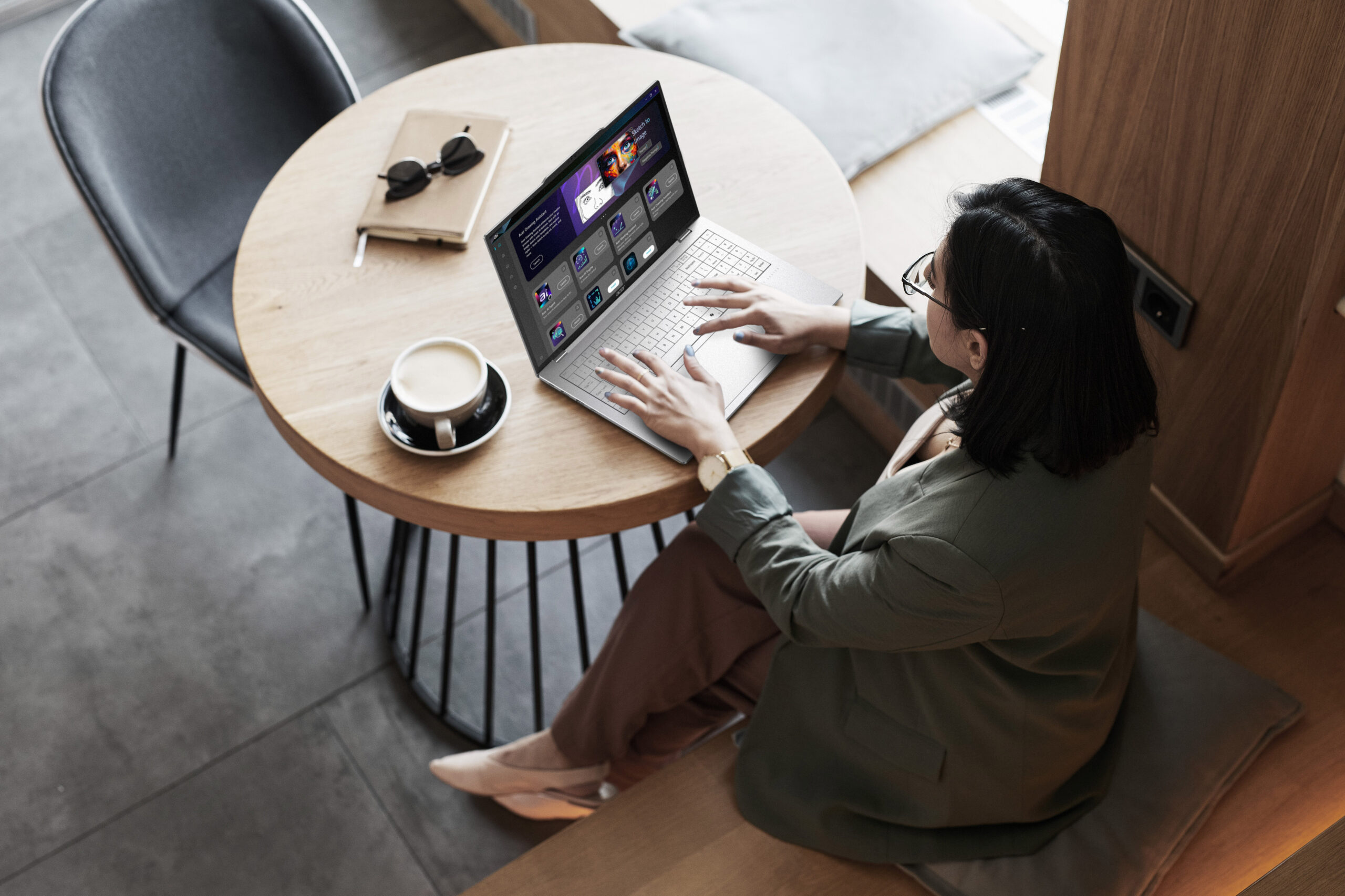 An overhead view of a person sitting at a table on a laptop.