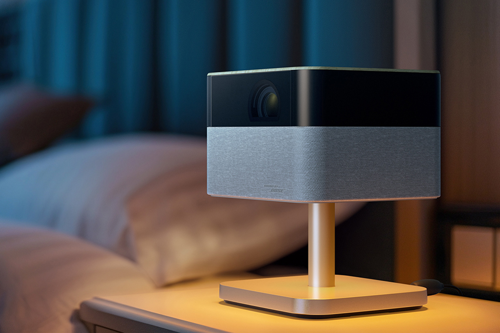 The Epson Lifestudio Flex Plus projector casting a soft glow on a nightstand.