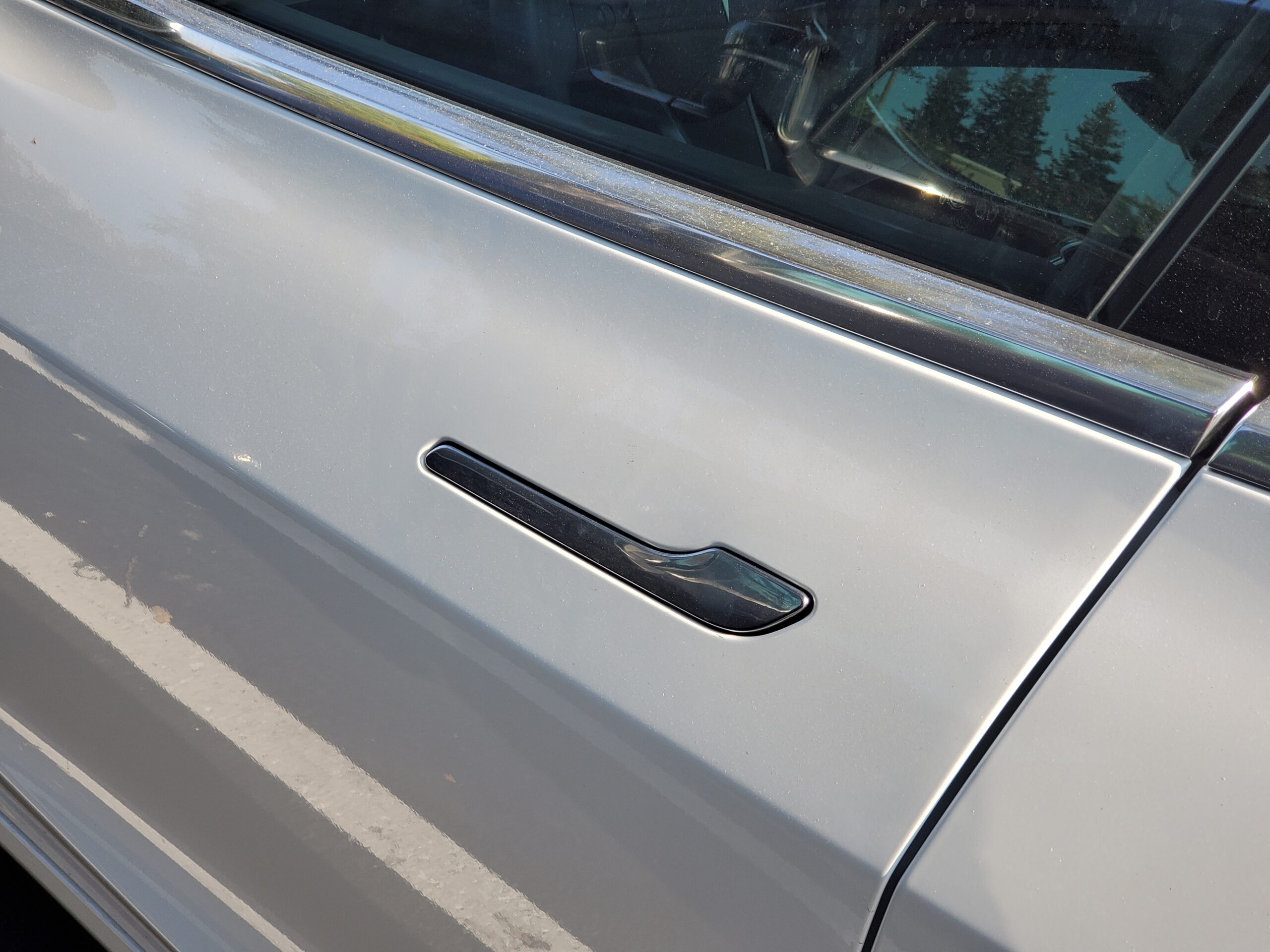 Close-up of flush-mounted, retracting door handle on Tesla automobile