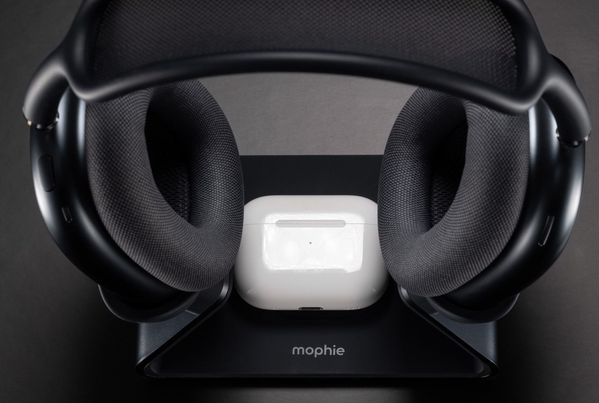 An AirPods charging case sitting on the base of Mophie’s new AirPods Max charging stand.