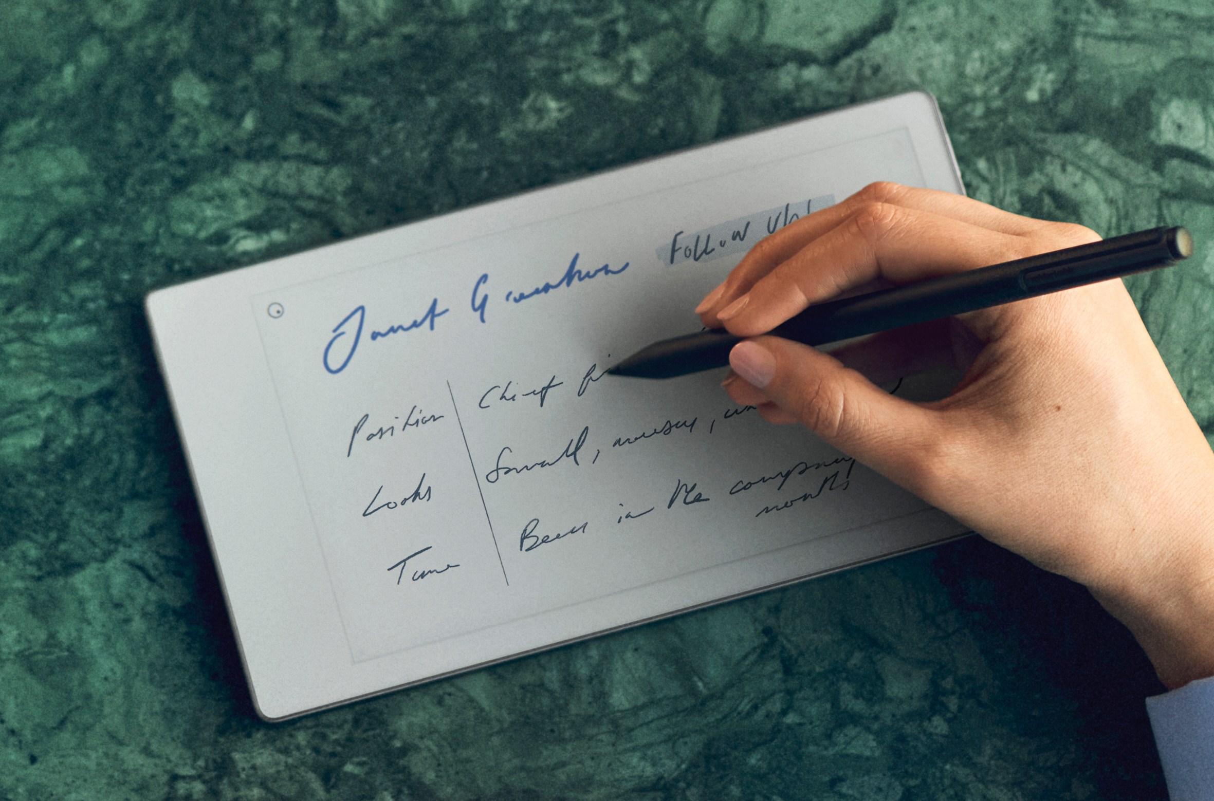 A person uses a stylus to write on the Remarkable Paper Pro Move in landscape mode.