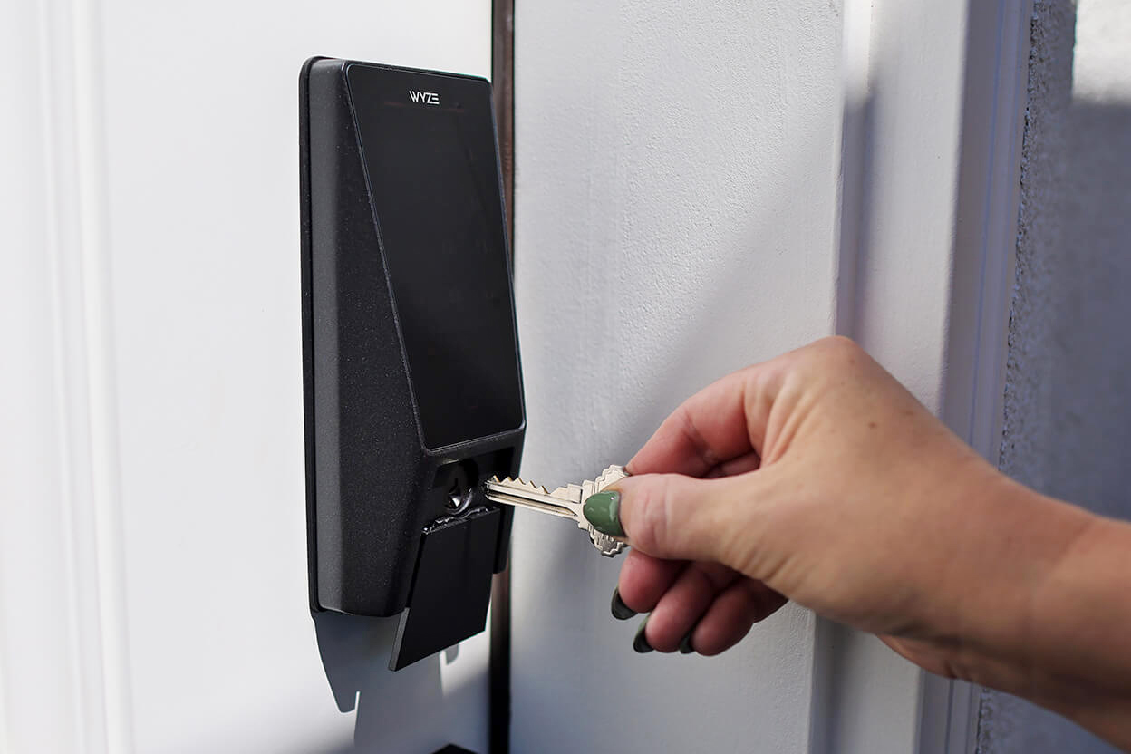A person inserts a key into the Wyze Palm Lock.