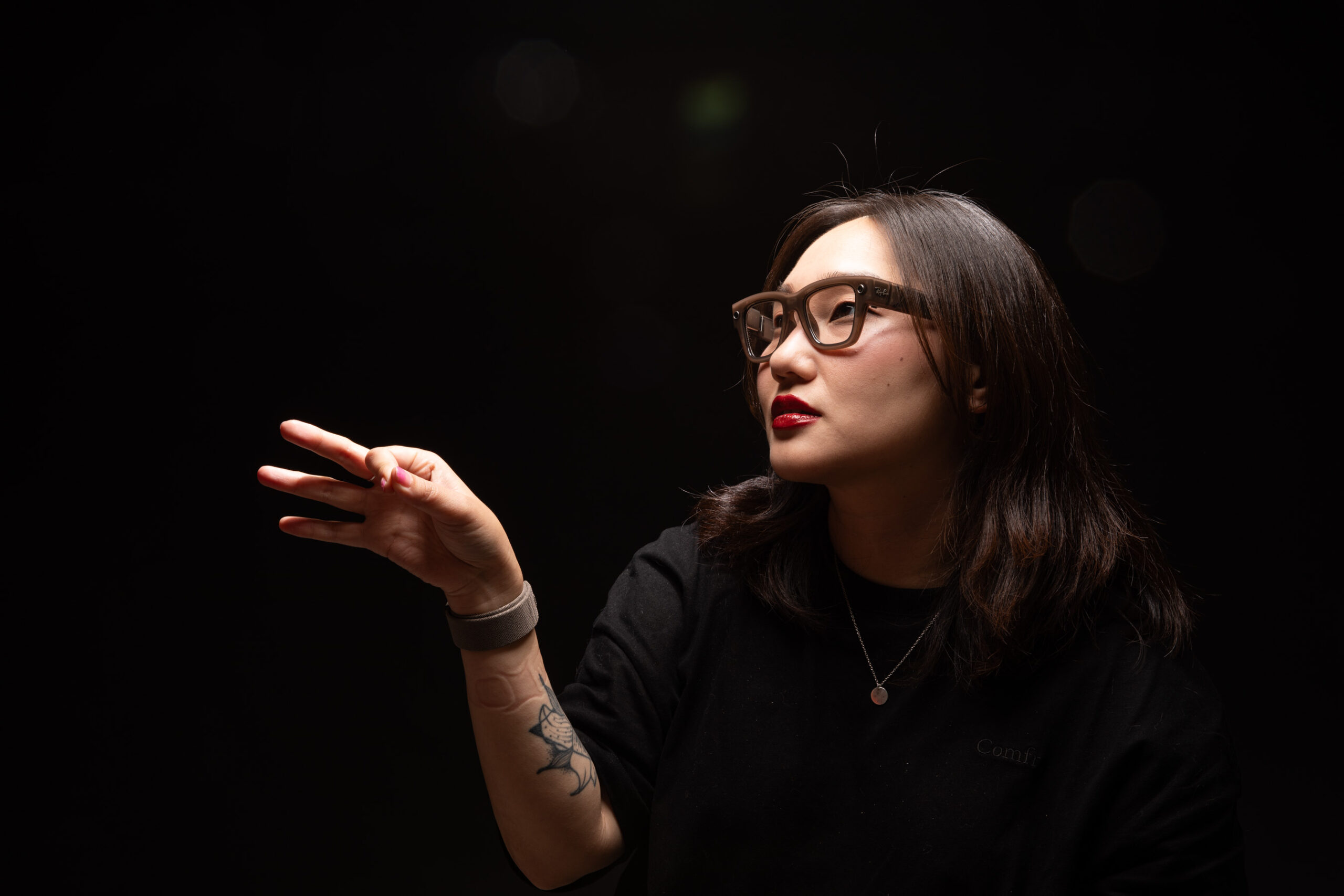 Senior reviewer Victoria Song wearing the Meta Ray-Ban Display and Neural Band while pinching a finger.