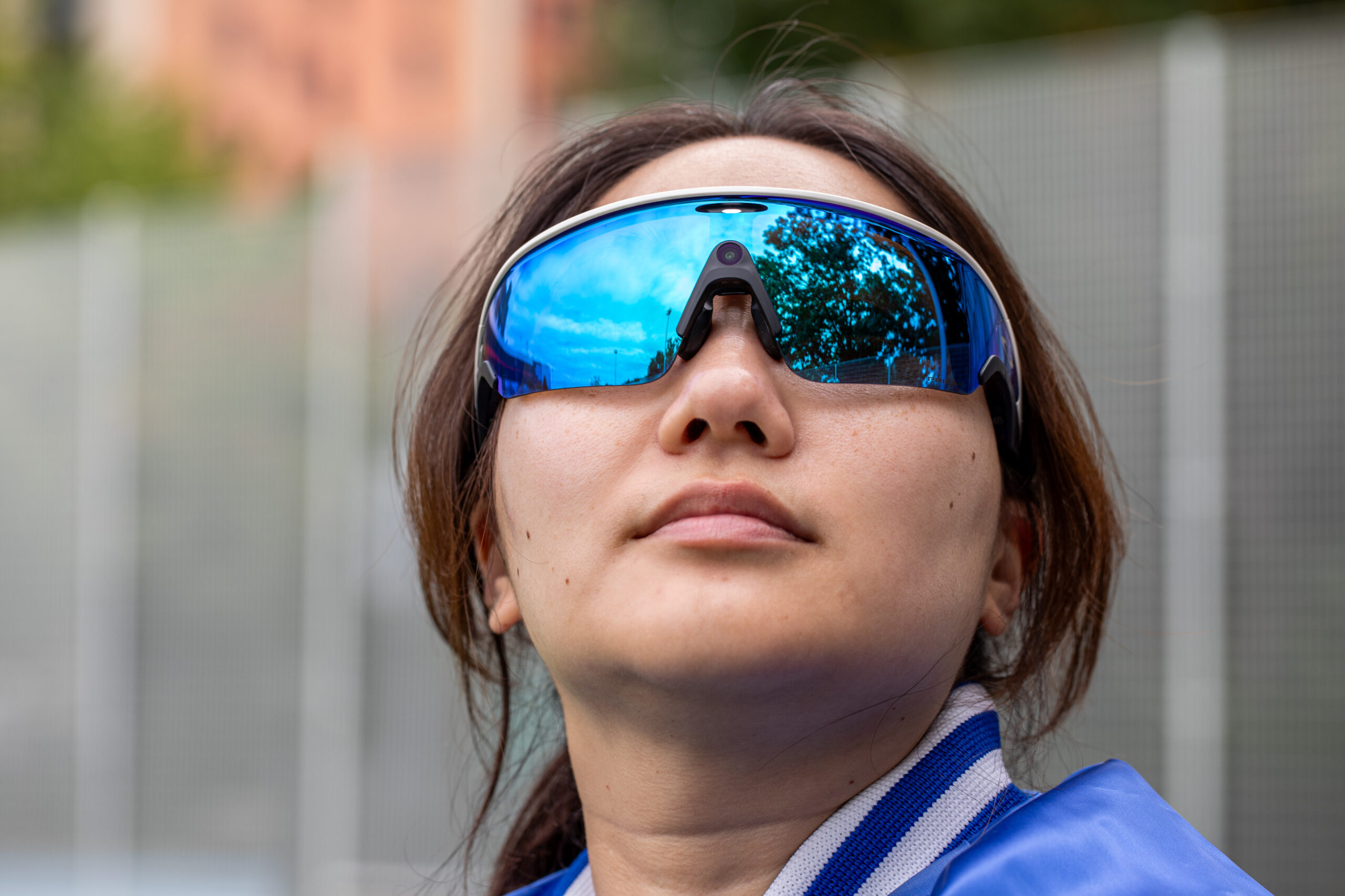 A person wearing a pair of blue Oakley Meta Vanguard glasses