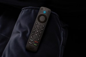 A photo of the Amazon Alexa Voice Remote Pro on a couch arm.