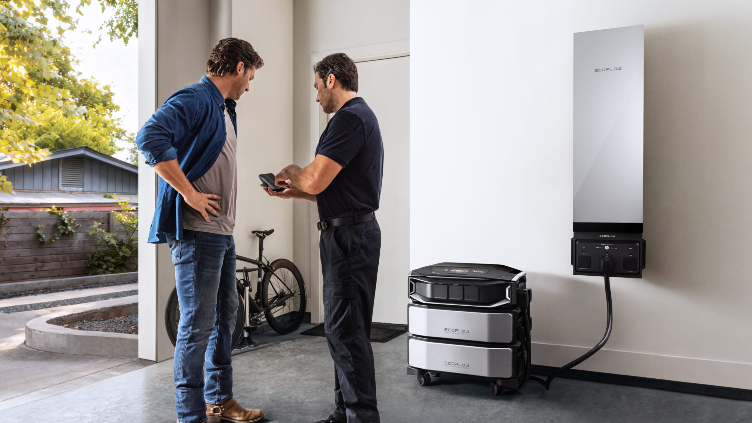 An electrician shows another man an app controlling the Delta Pro Ultra X and Smart Home Panel 3 in the background.