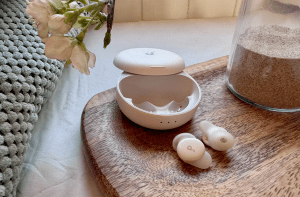 The Anker Soundcore Sleep A30 earbuds next to their case.