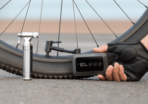 The Hoto Air Pump Pocket being held by a hand and pumping up a bike tire.