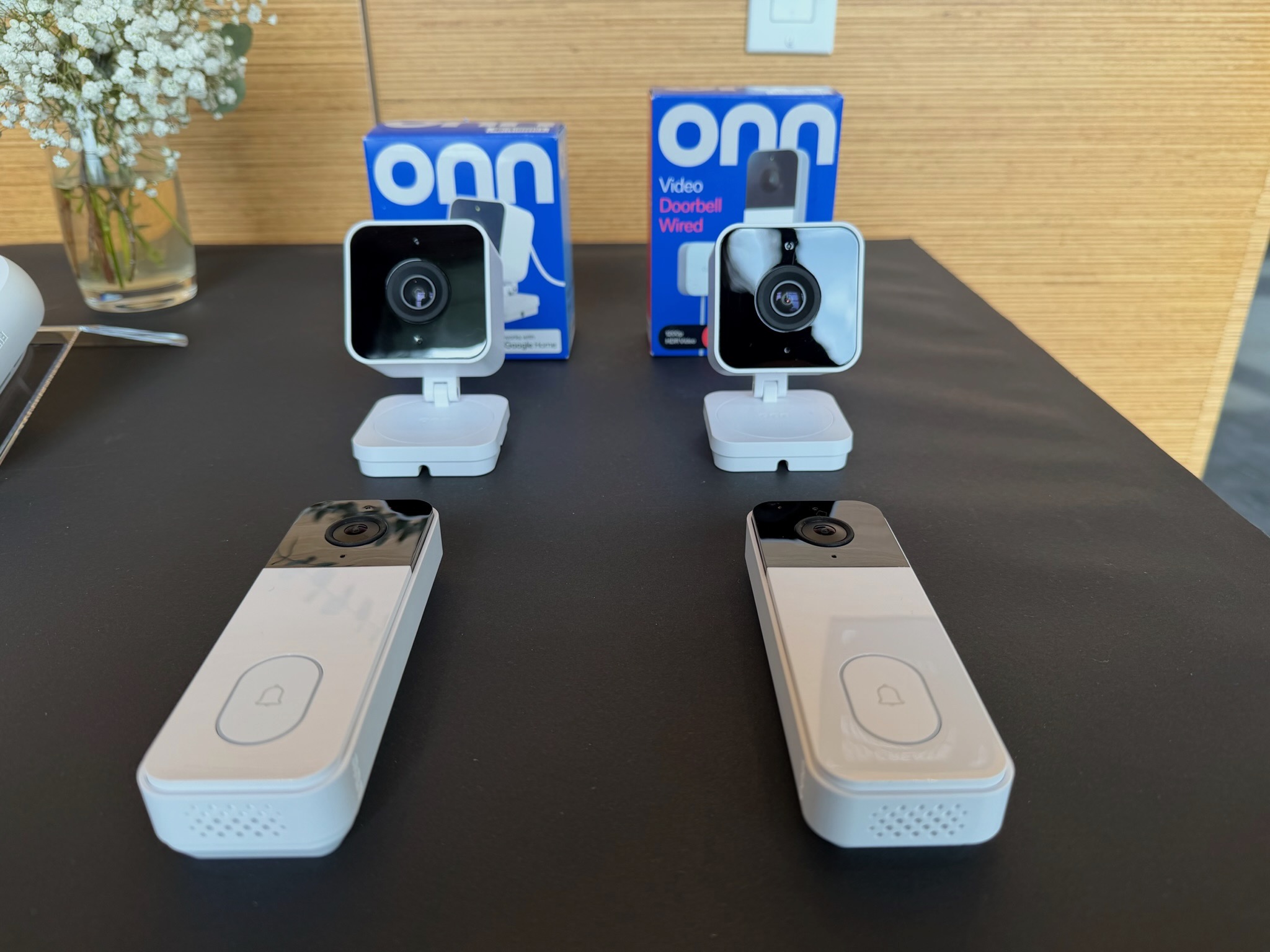 Two cameras and two video doorbells on a table.