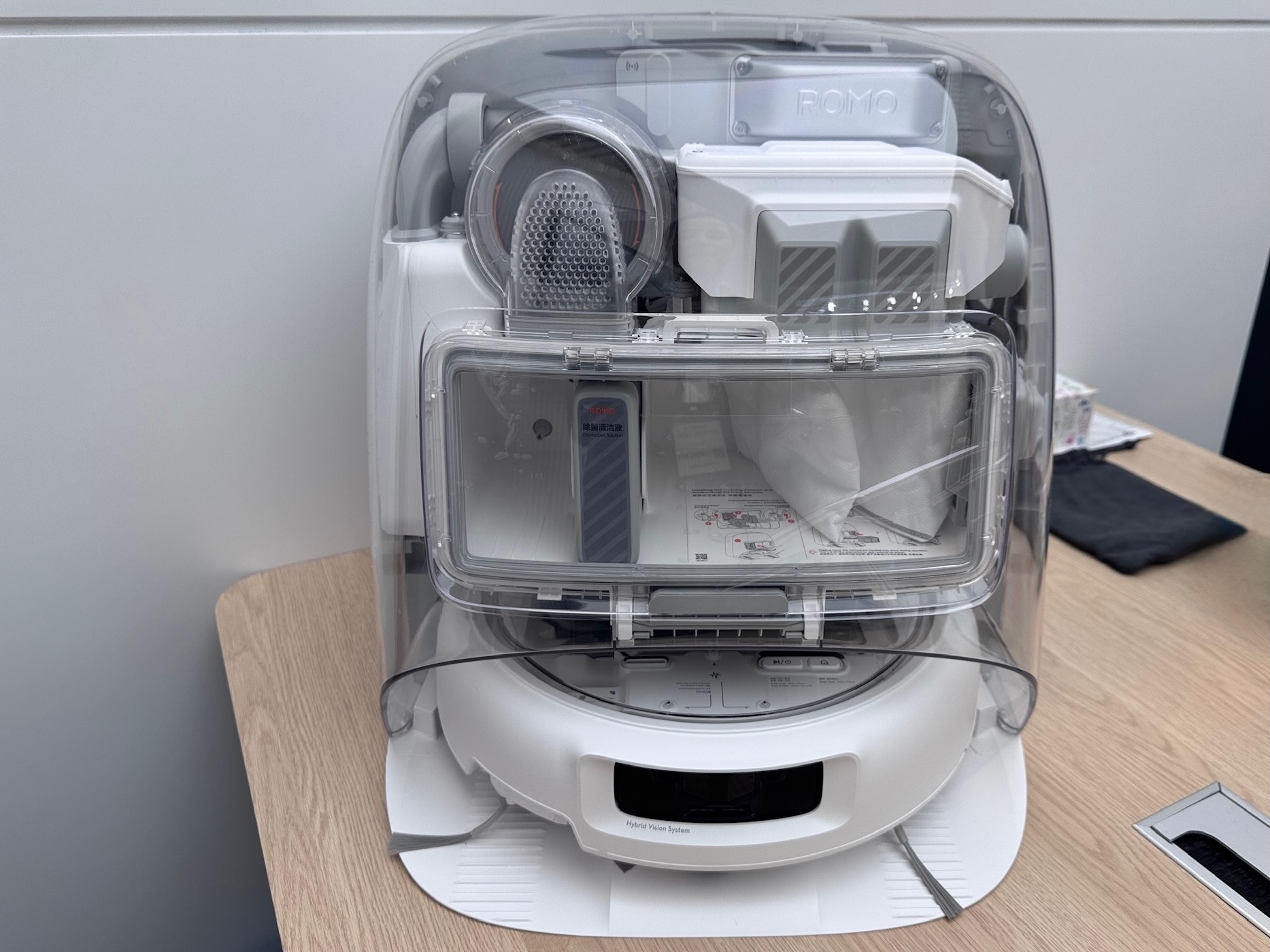 A transparent robot vacuum dock on a desk