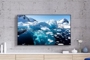 LG's QNED82A 4K TV mounted to a wall above an entertainment console.