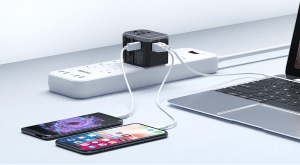 Travel adaptor on power strip connected to phones and laptop.