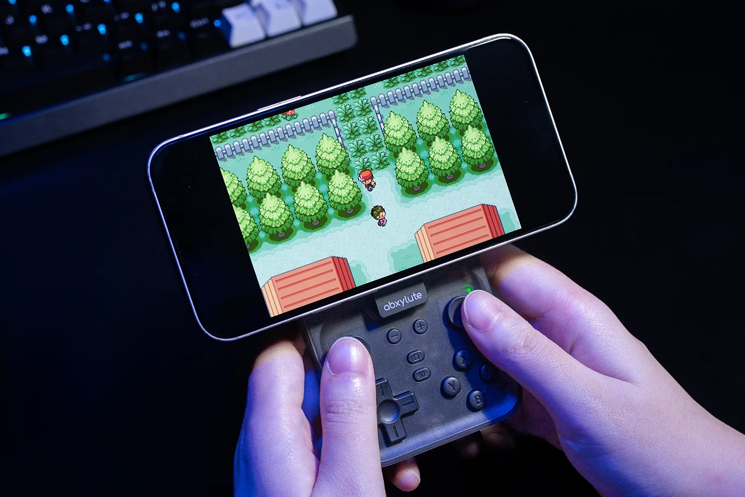 A person holds the Abxylute M4 Snap-On controller while playing a game on a smartphone.