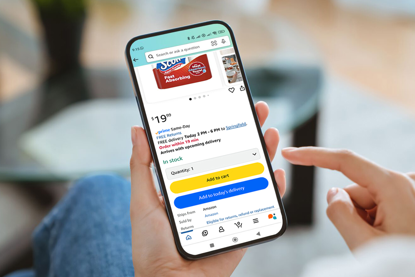 A person holding a smartphone with Amazon’s online store on screen.