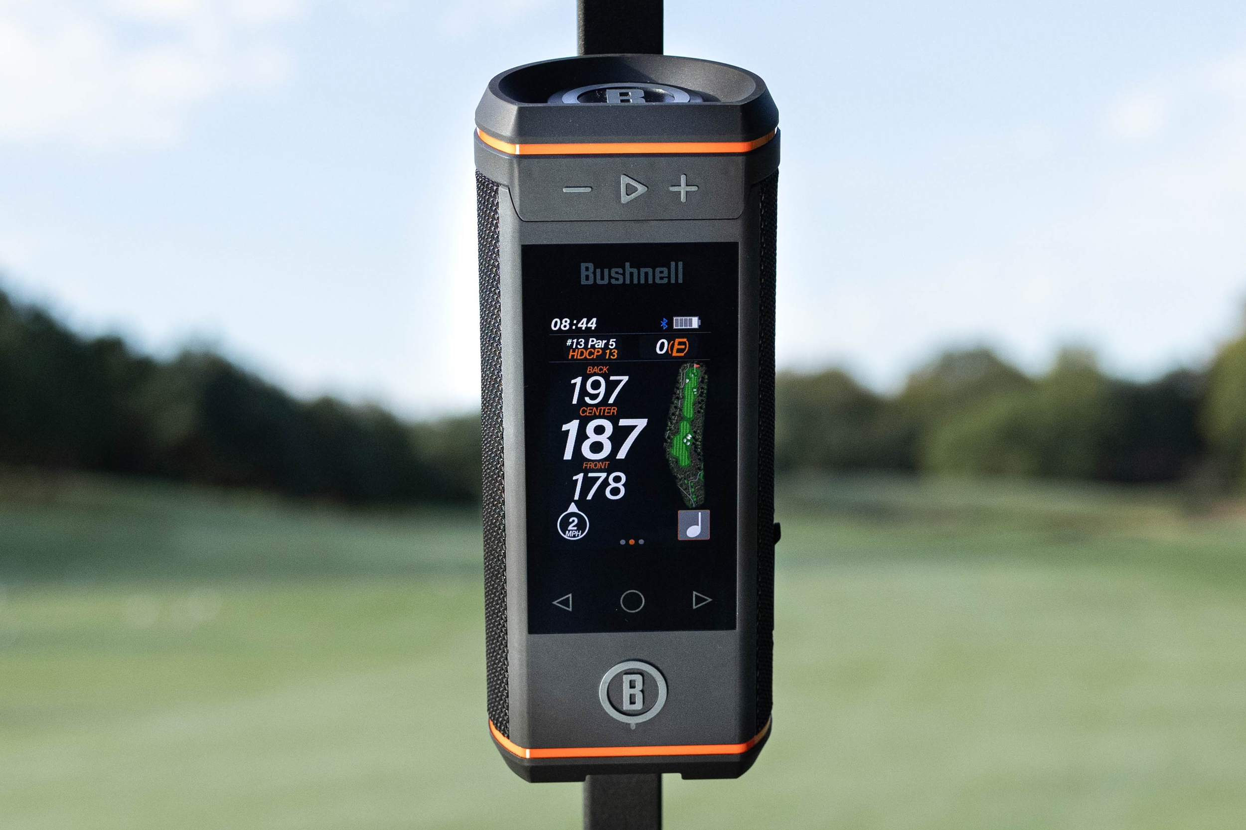 The Bushnell Wingman HD Bluetooth speaker magnetically attached to a golf cart.