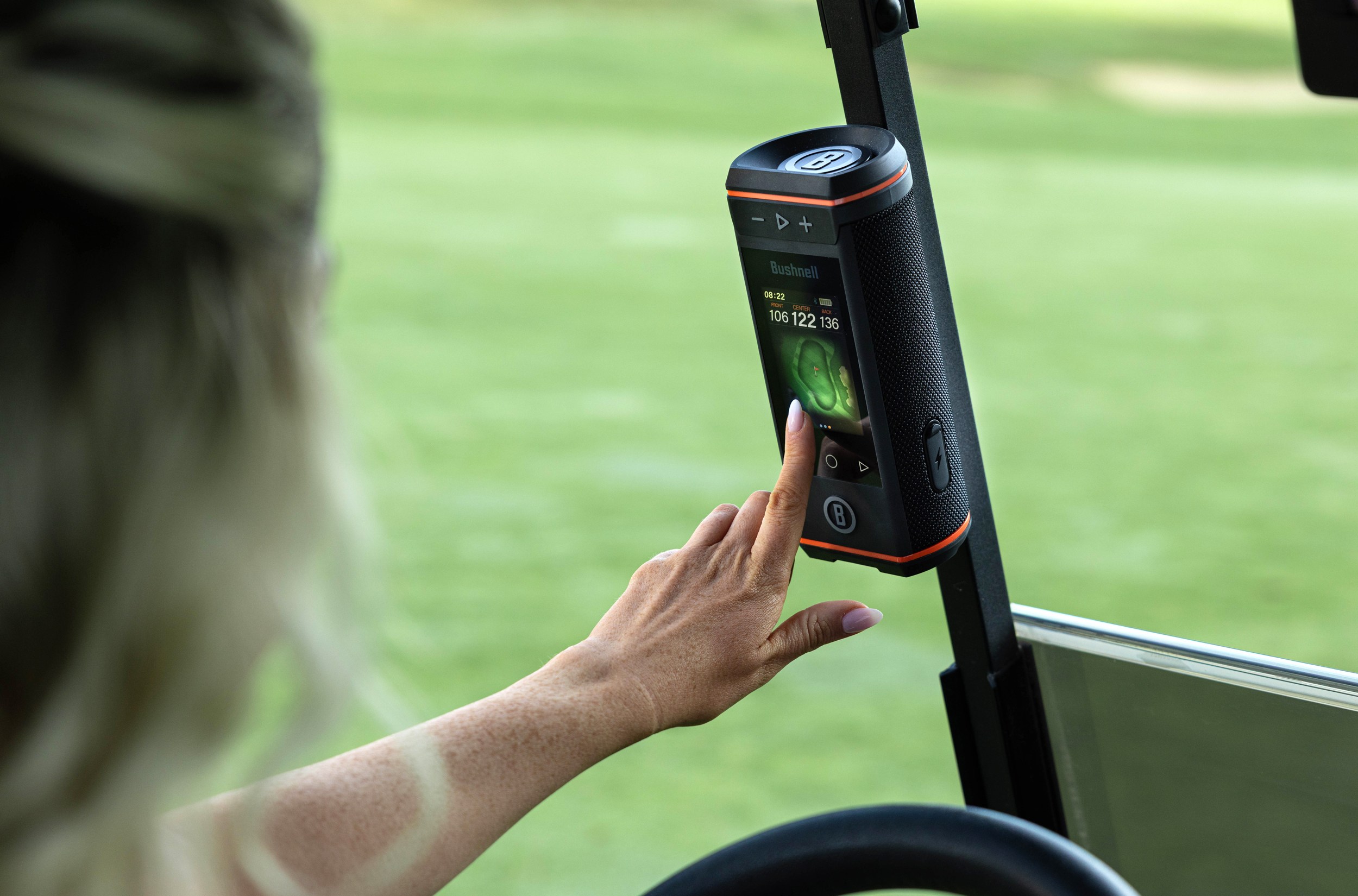 A person touches the screen on the Bushnell Wingman HD Bluetooth speaker.