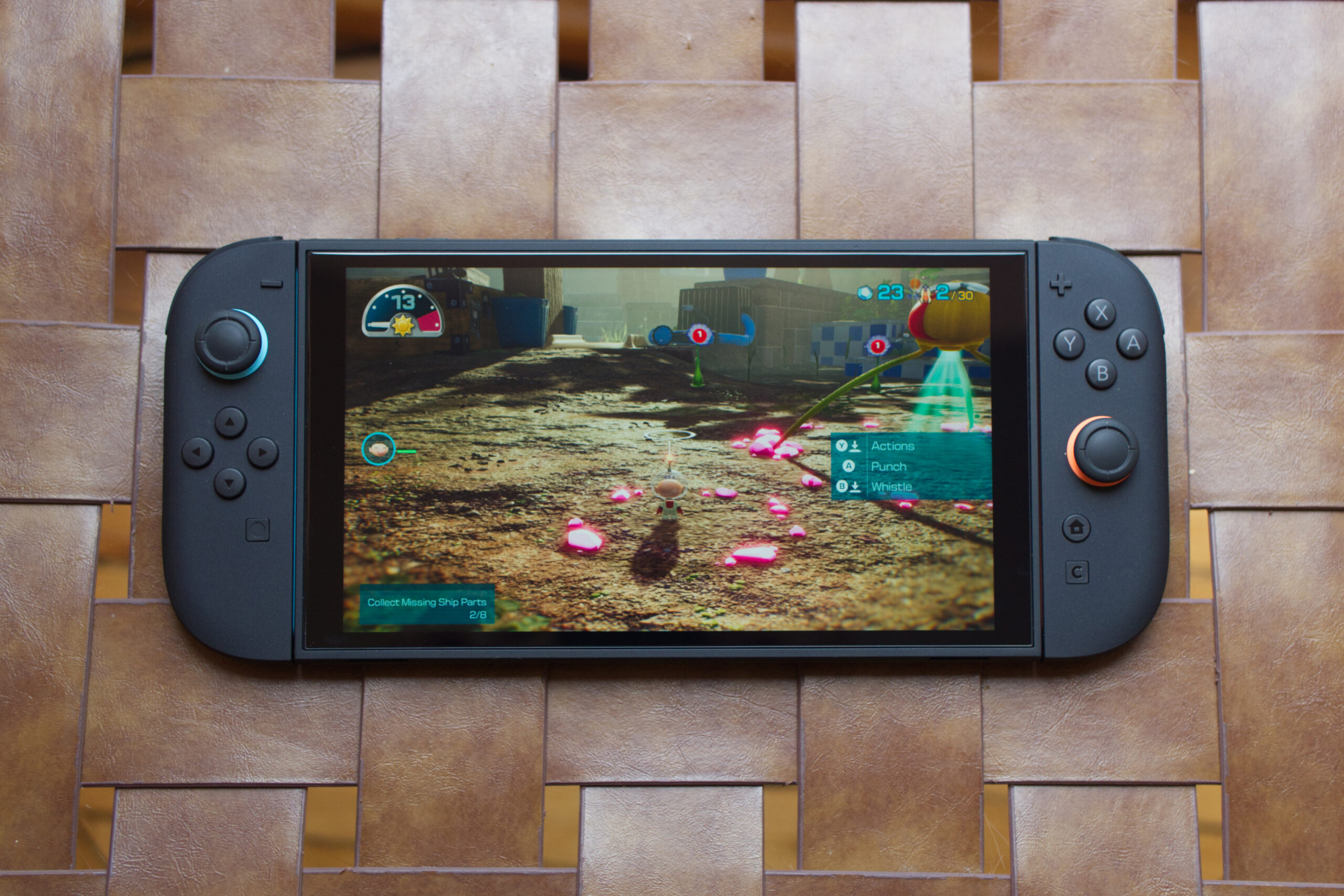 An image showing the Nintendo Switch 2 playing Pikmin 4 on a faux leather-clad ottoman.