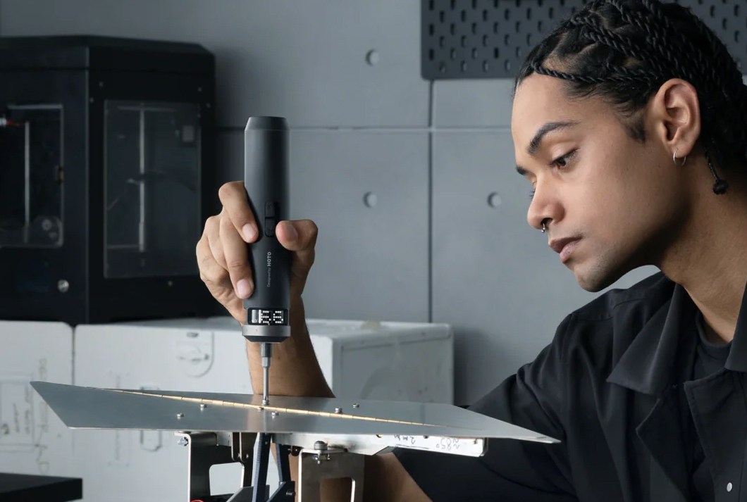 A person using the Hoto PixelDrive on. screw. A person using the Hoto PixelDrive on. screw.