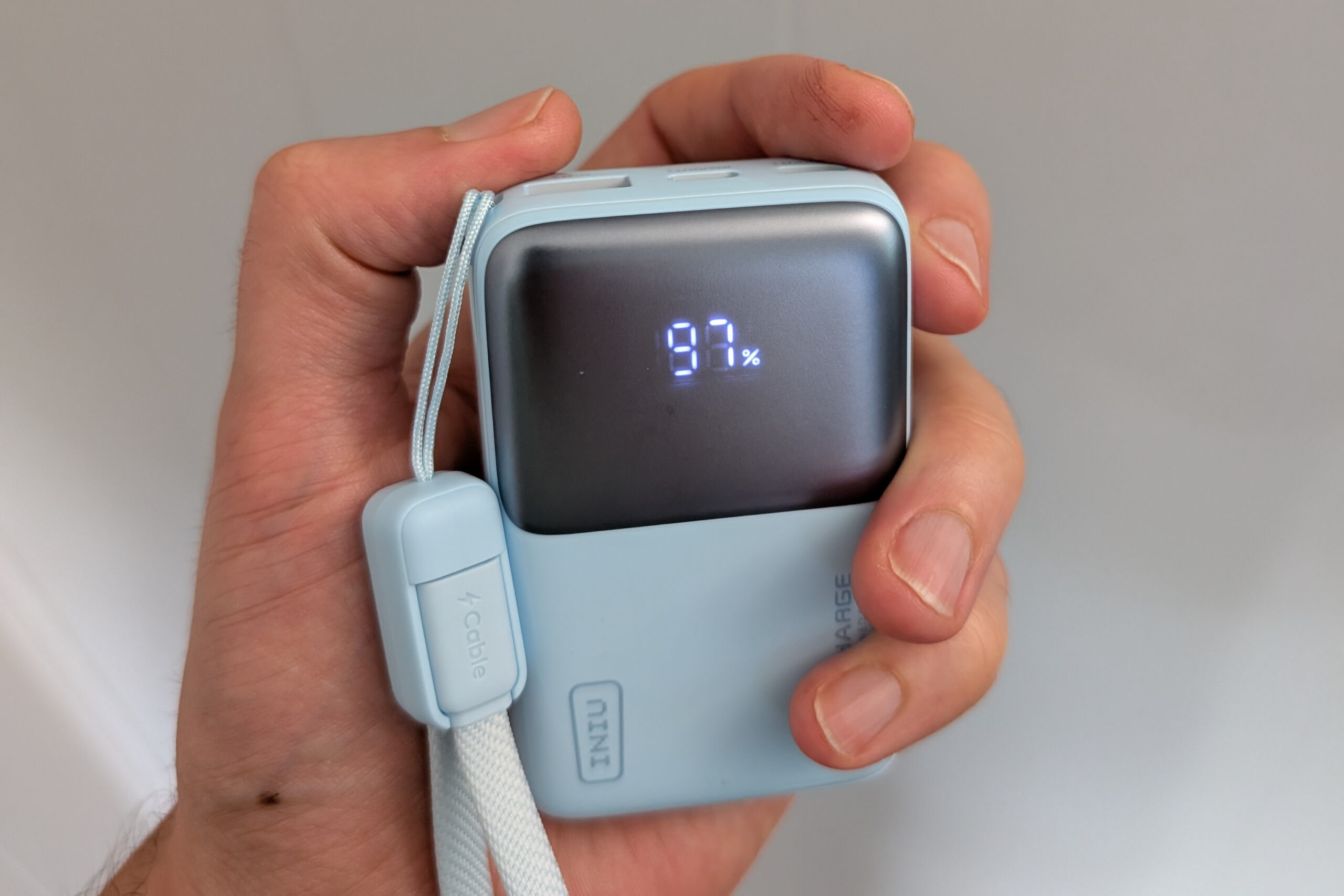 An image of the Iniu Pocket Rocket P50 in sky blue held in the hand.