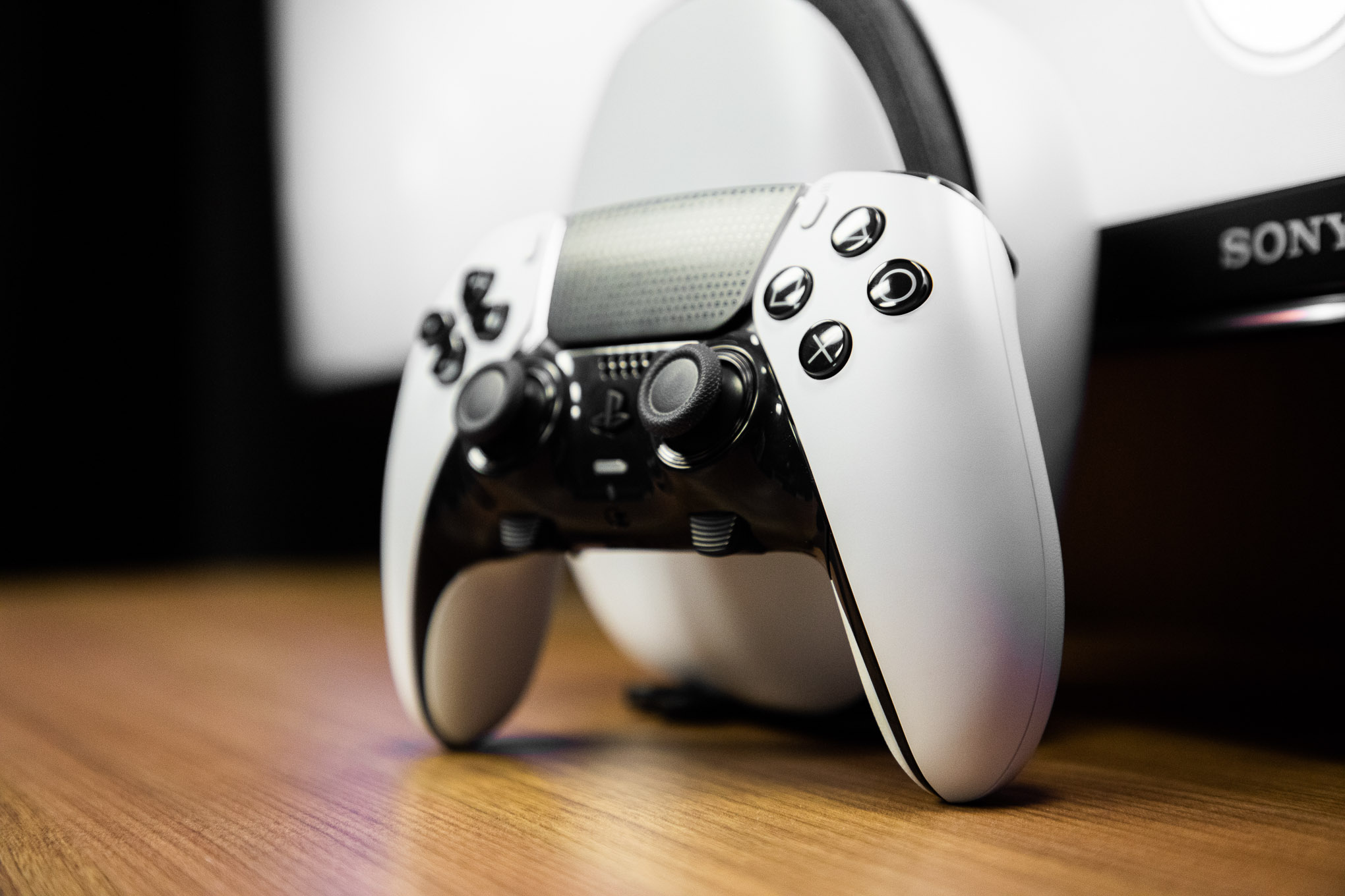 controller standing on a wooden table, wood grain running toward the camera at a slight angle