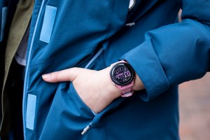 Close-up of the Garmin Forerunner 265S on the wrist of a person putting their hand into a jacket pocket.