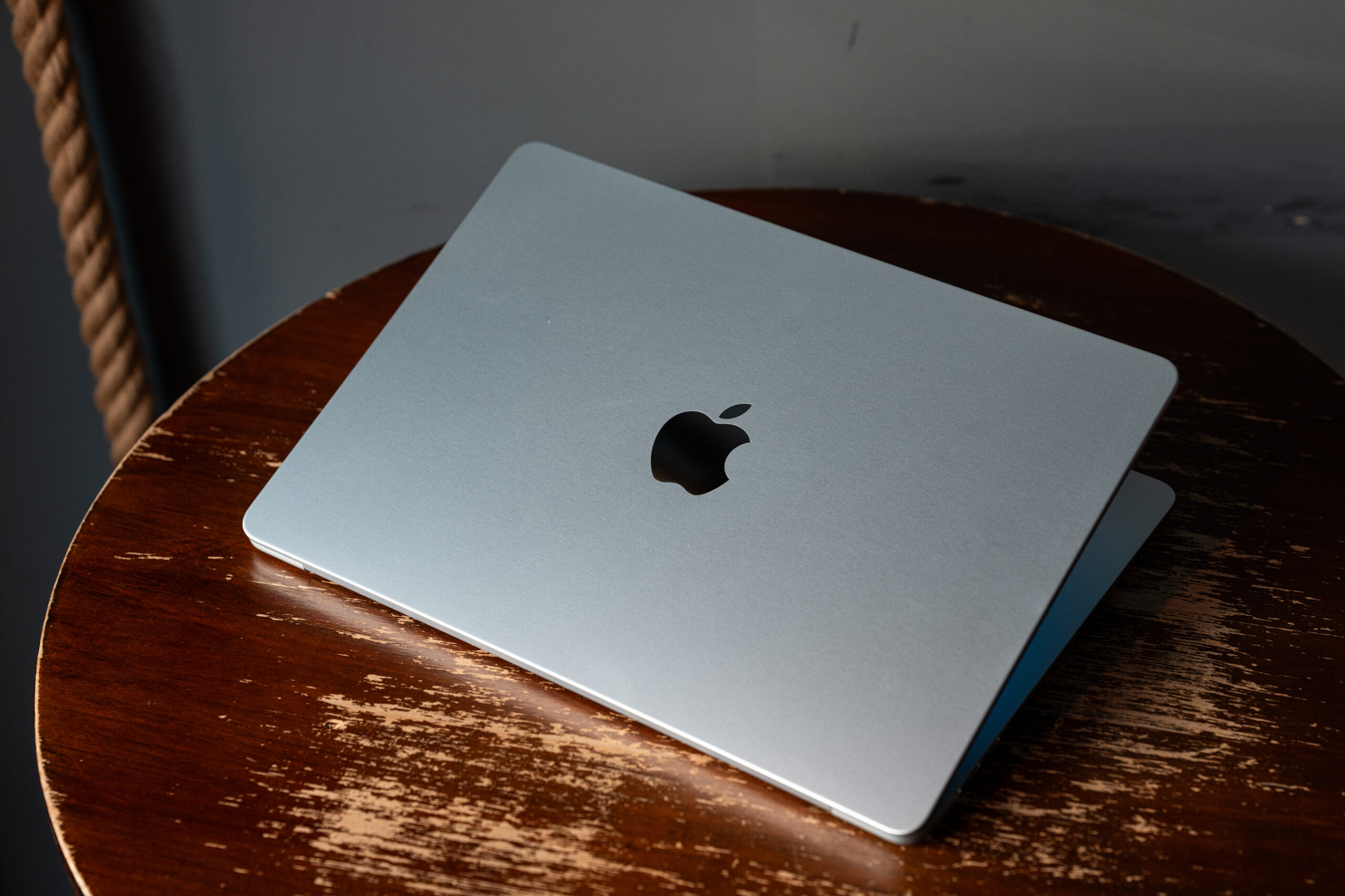 An Apple M4 MacBook Air sitting on a wooden circular table with its screen facing away from the viewer.