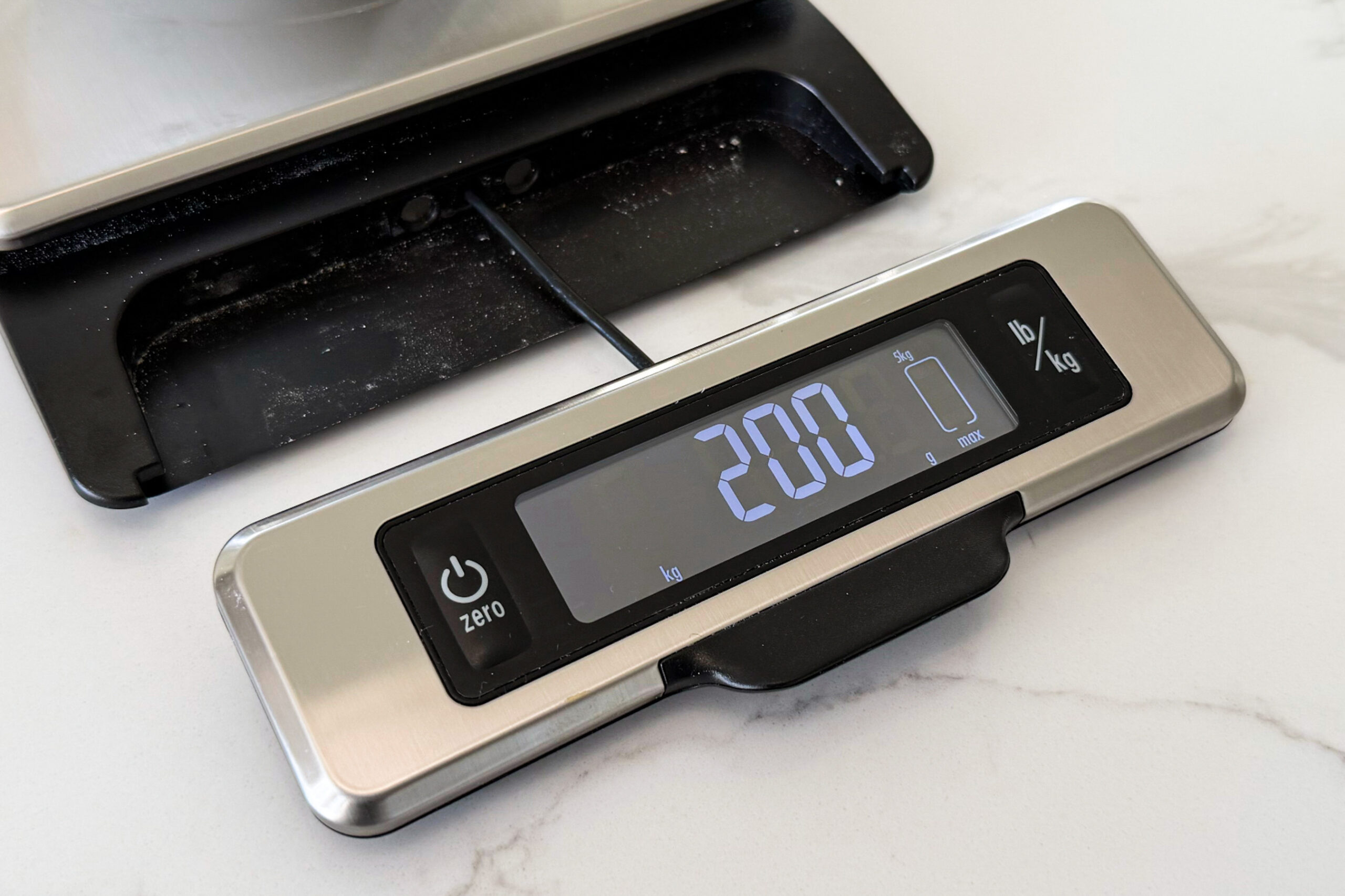 Front of kitchen scale with LED panel pulled out, connected by a single wire.