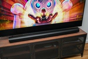 A photo of the Sonos Arc Ultra soundbar in front of a television on a stand.