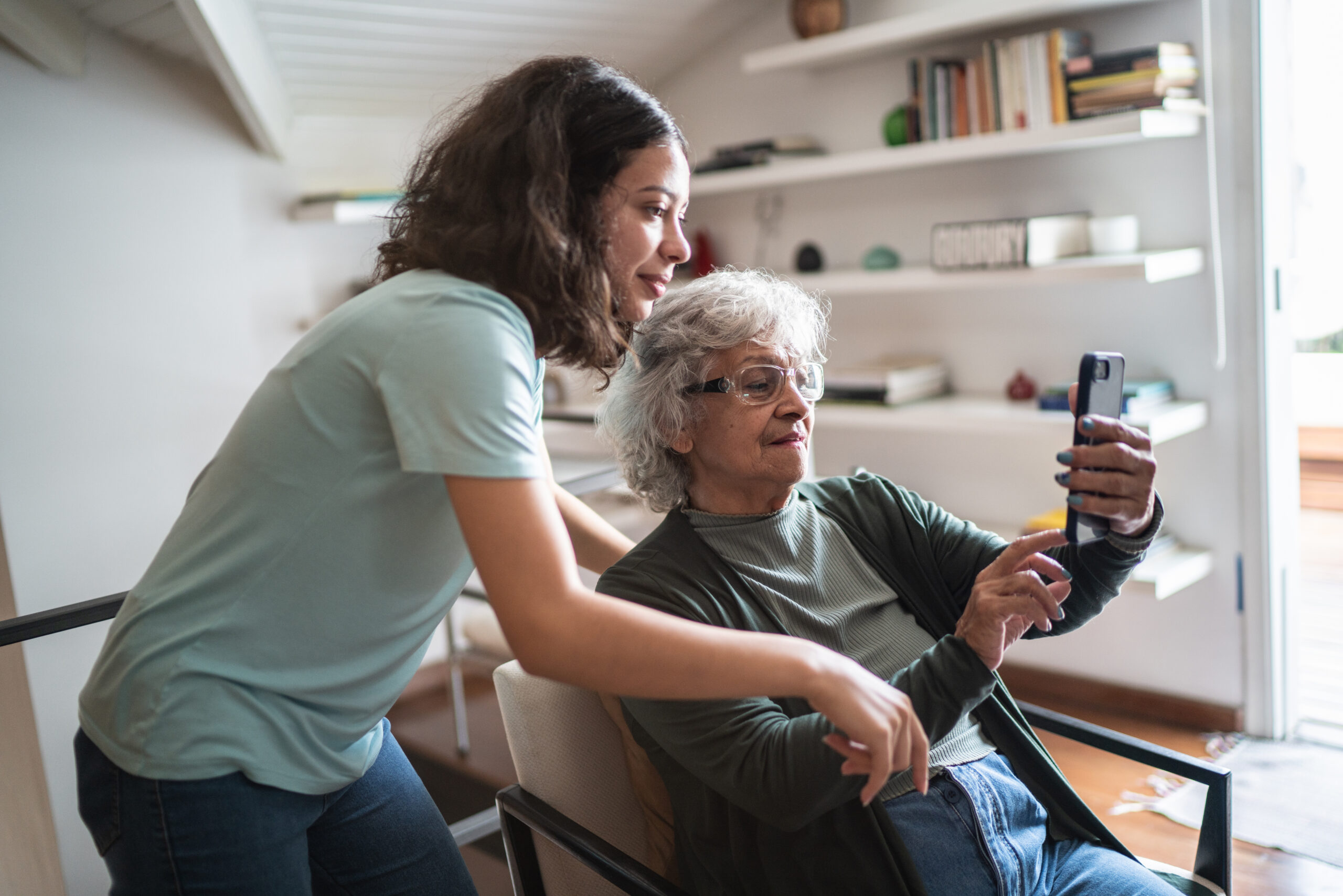Grandmother and granddaughter using the mobile phone at home