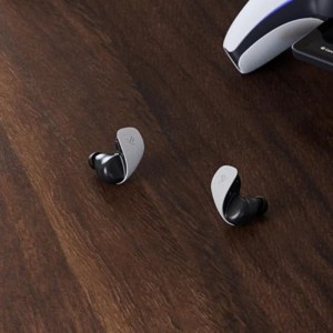 Pulse Explore Wireless Earbuds on a wooden table near a PlayStation Portal.