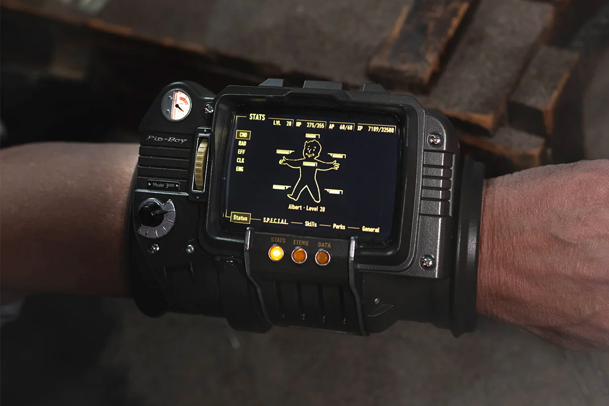 Bethesda’s new Pip-Boy 3000 replica on a person’s wrist showing health metrics on screen.