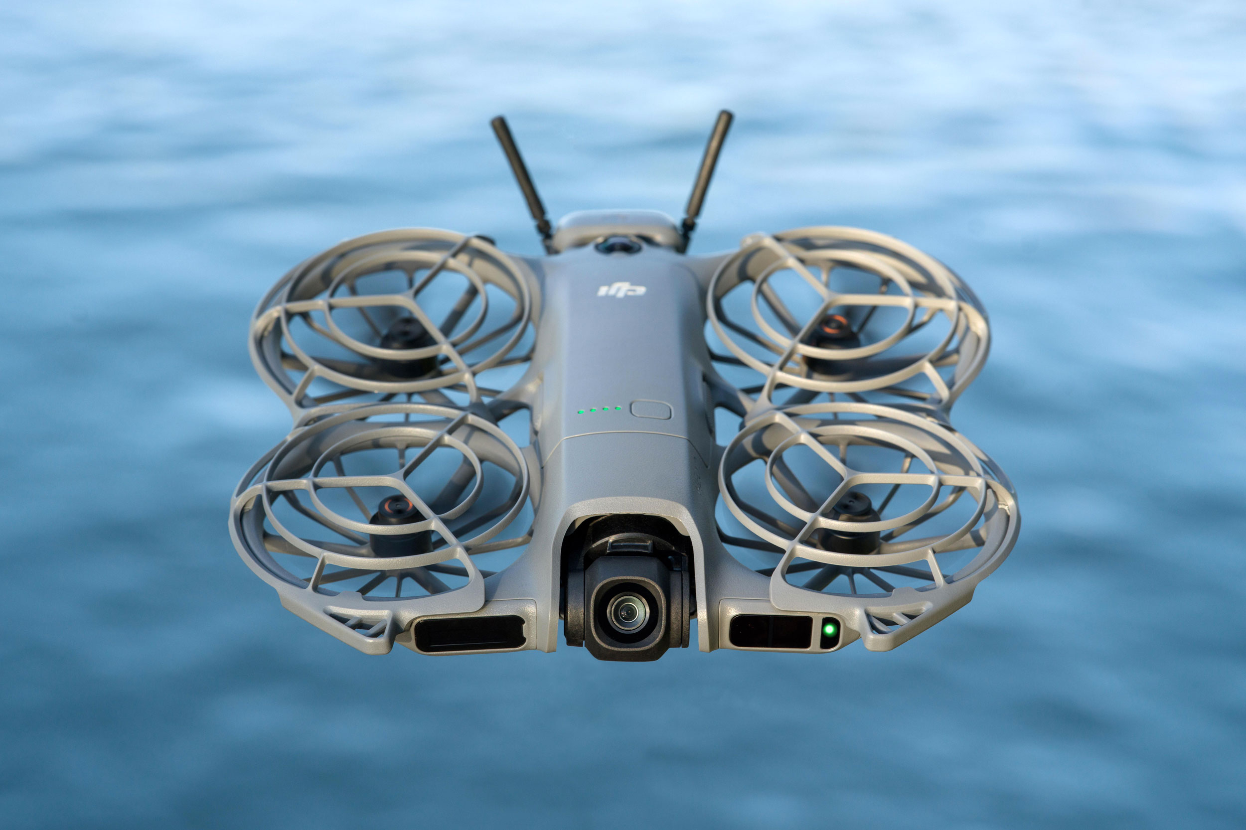 The DJI Neo 2 selfie drone floating over water.