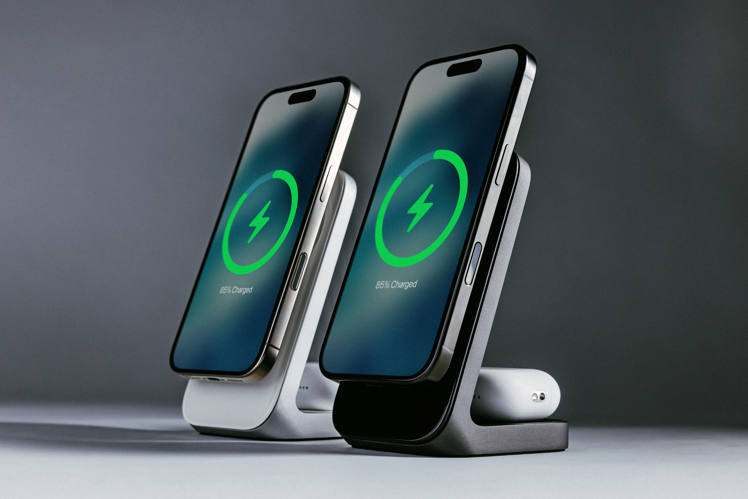 Two Nomad Stand One wireless charging stands with iPhones and AirPods being charged.