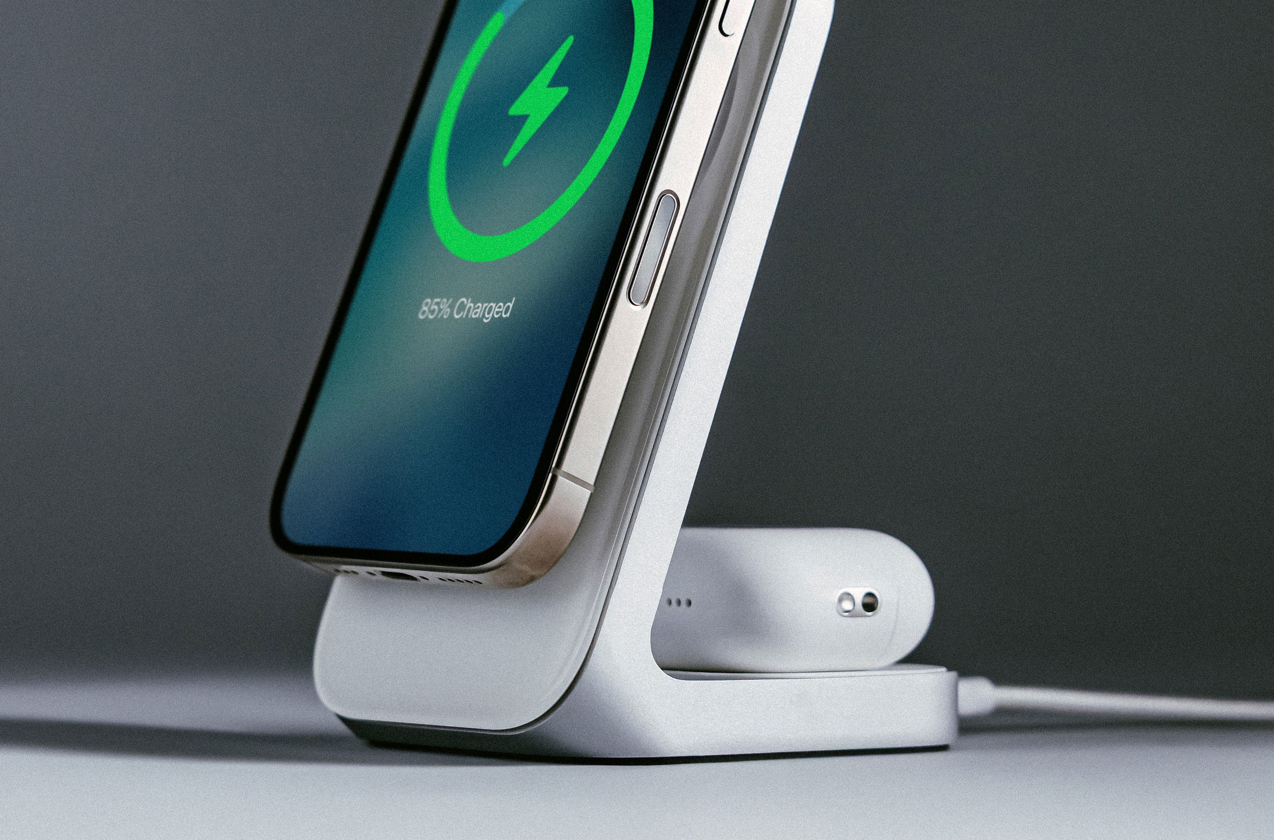 An iPhone and Apple AirPods charging on Nomad’s Stand One charger.