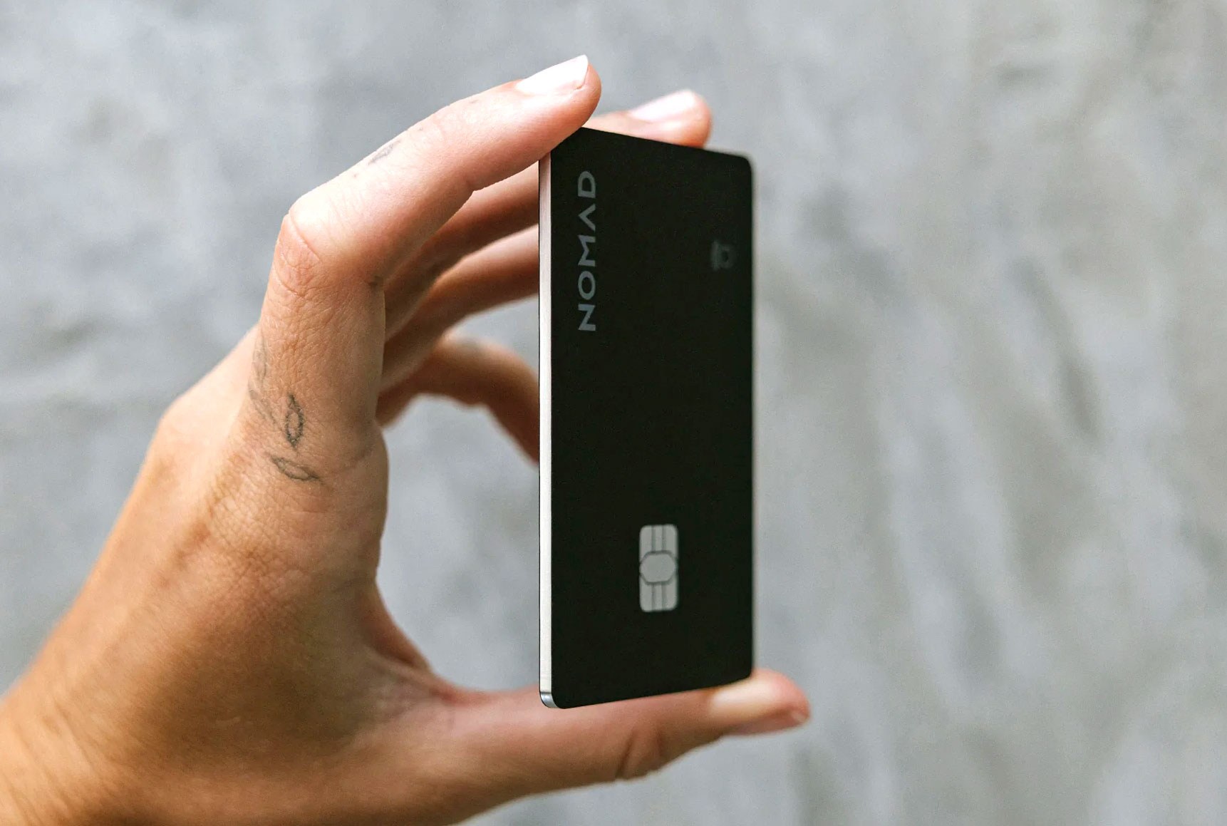 A person holds the Nomad Tracking Card Pro between their fingers. A person holds the Nomad Tracking Card Pro between their fingers.