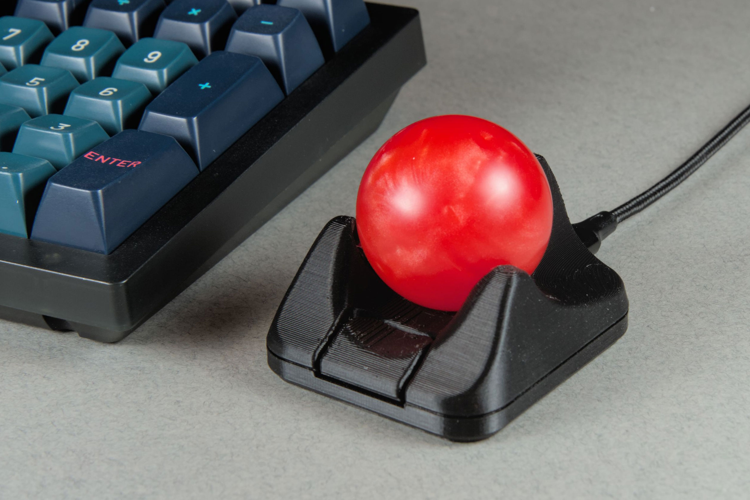 The Ploopy Nano 2 trackball next to a computer keyboard.