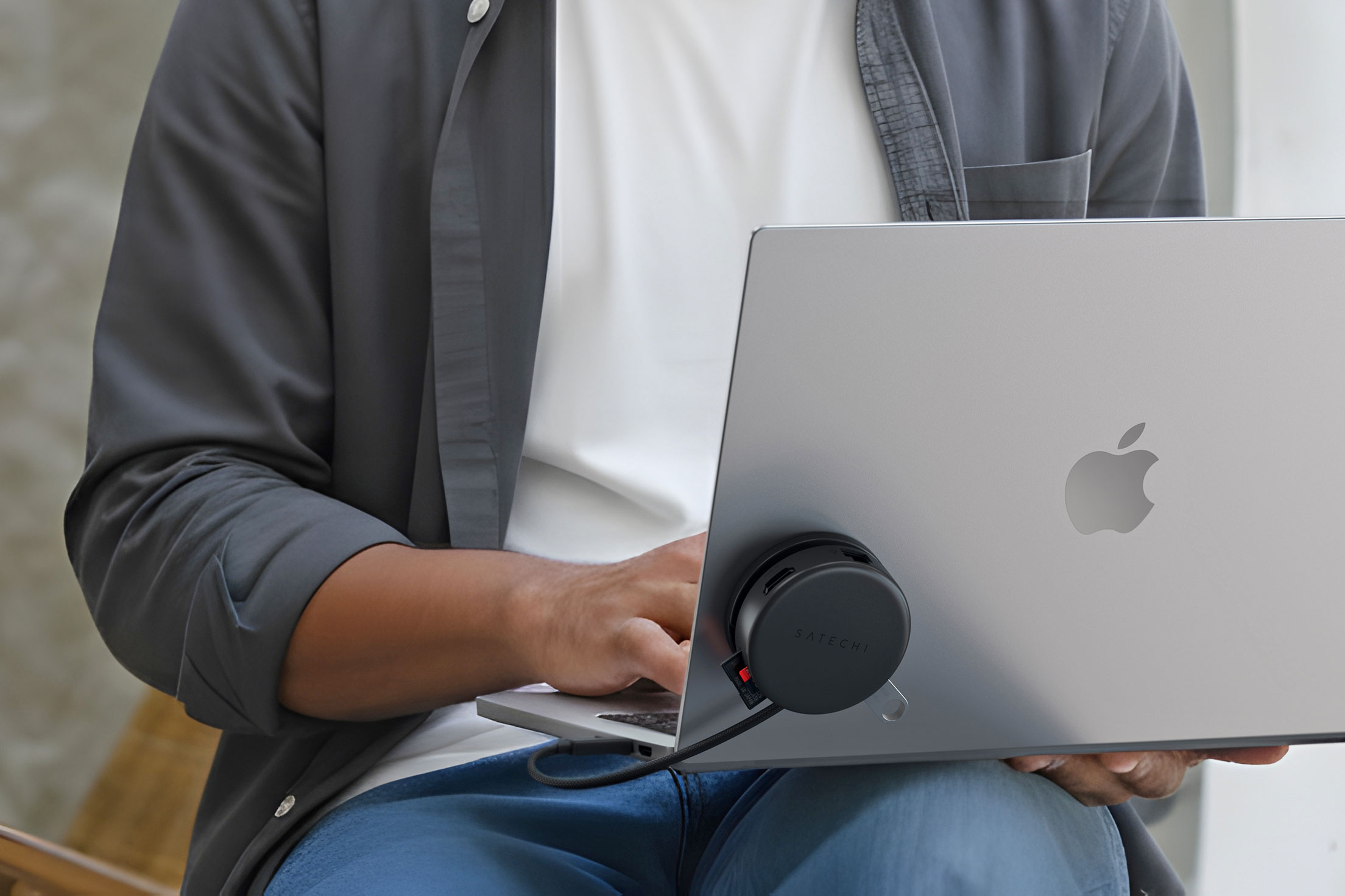 Satechi’s puck-shaped hub attached to the lid of a MacBook laptop. Satechi’s puck-shaped hub attached to the lid of a MacBook laptop.