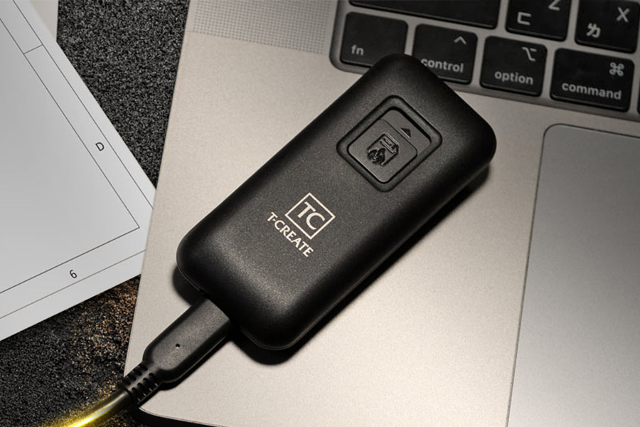 The TeamGroup T-Create Expert P35S SSD drive connected to a USB-C cable and sitting on a laptop.