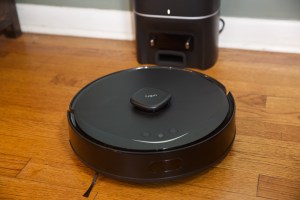 A black robot vacuum on a hardwood floor