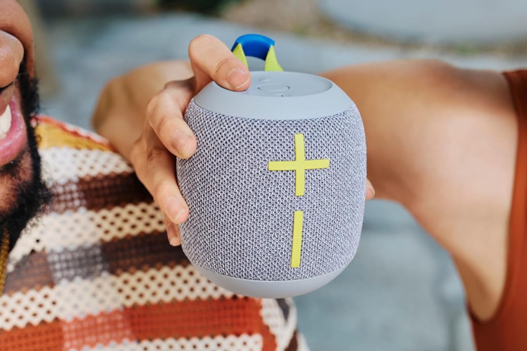 The UE Wonderboom 4 Bluetooth speaker being held.