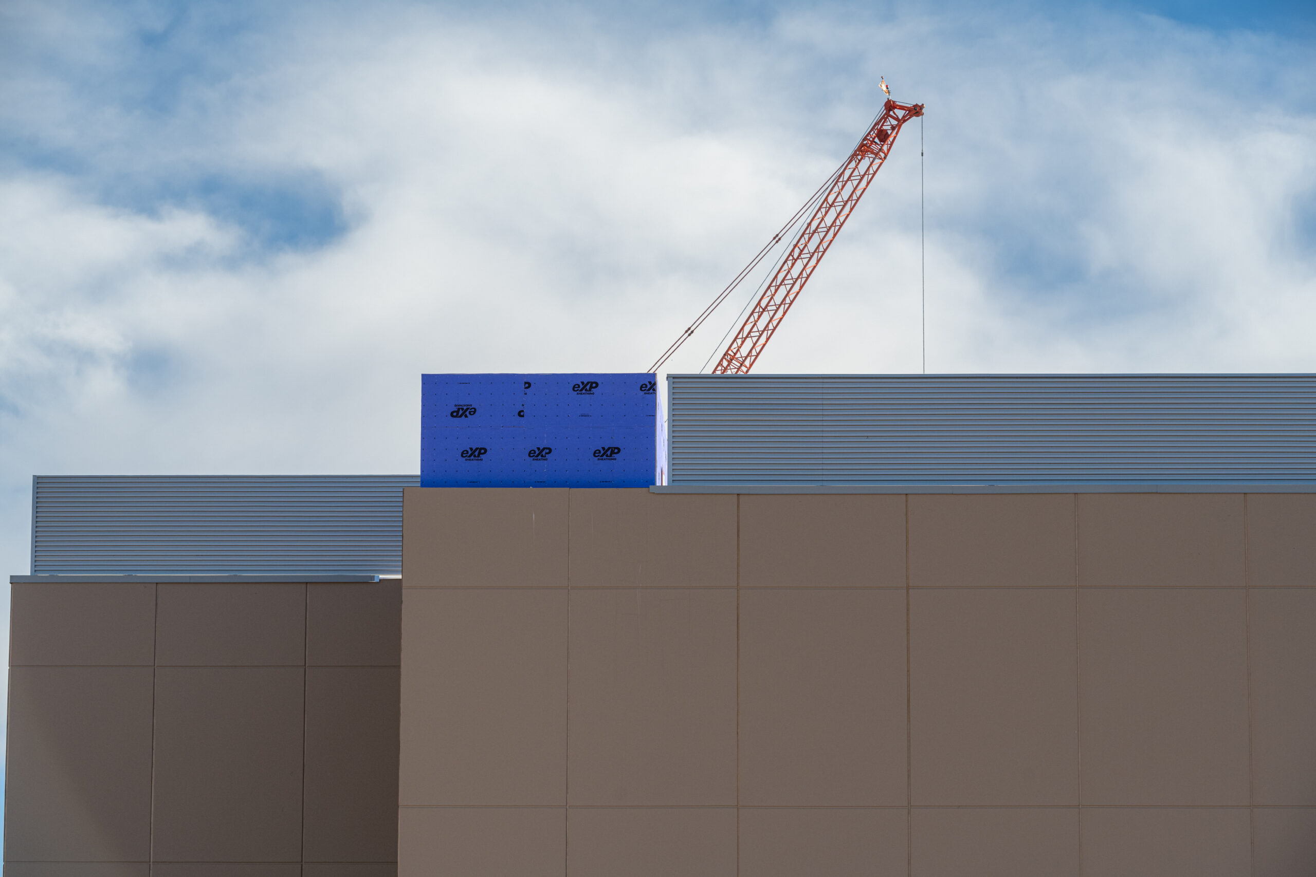 A construction crane looms over large buildings.