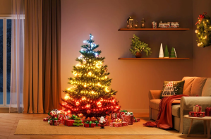 Govee’s Christmas Lights 2 wrapped around a Christmas tree in the middle of a living room near a fireplace.
