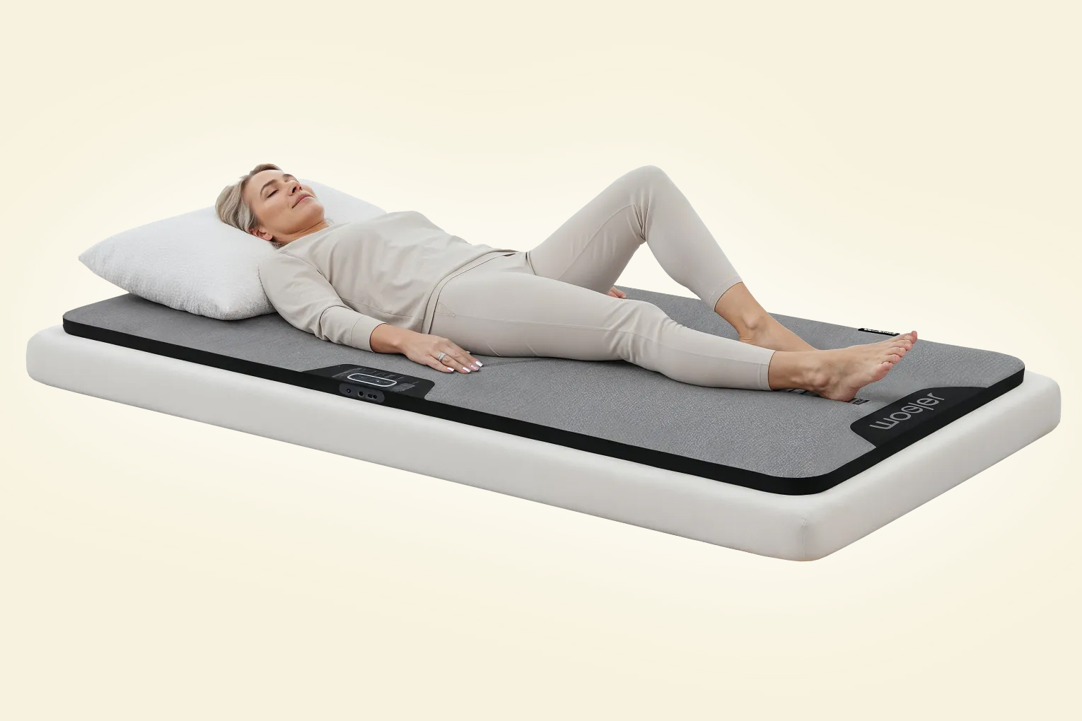 A person lays on the Woojer Mat that’s stretched out on a small mattress.