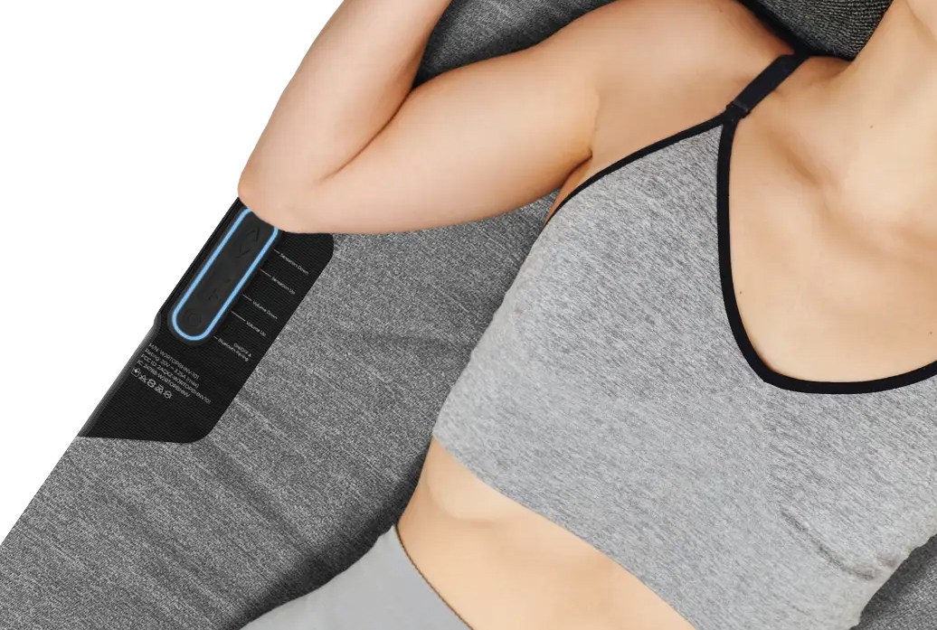 A person in workout attire lays on the Woojer Mat. A person in workout attire lays on the Woojer Mat.