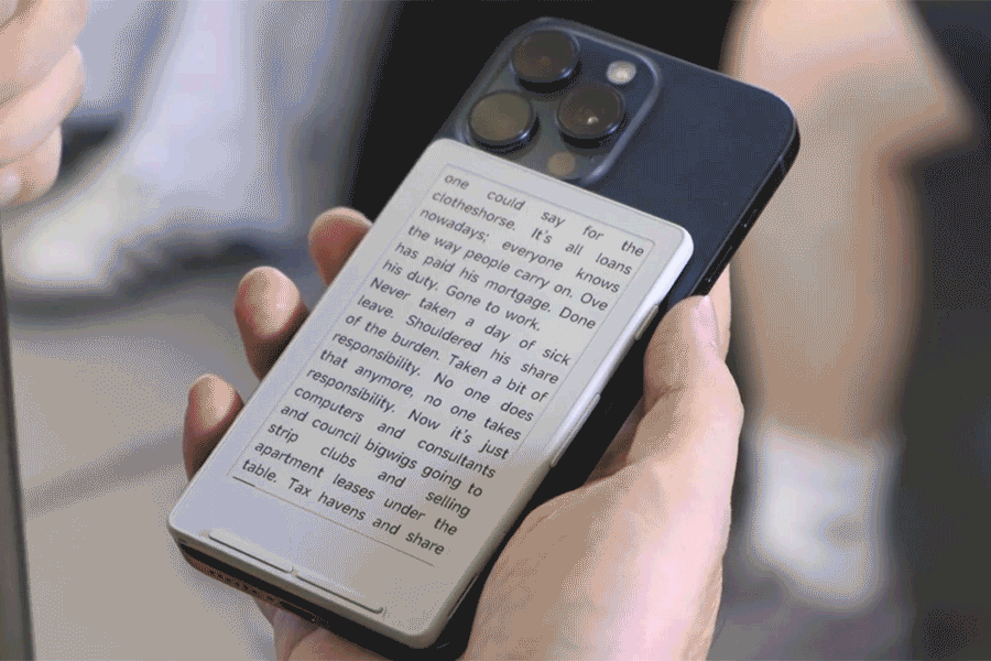 A short video clip showing someone flipping their phone over to reveal an e-reader stuck to the back. A short video clip showing someone flipping their phone over to reveal an e-reader stuck to the back.