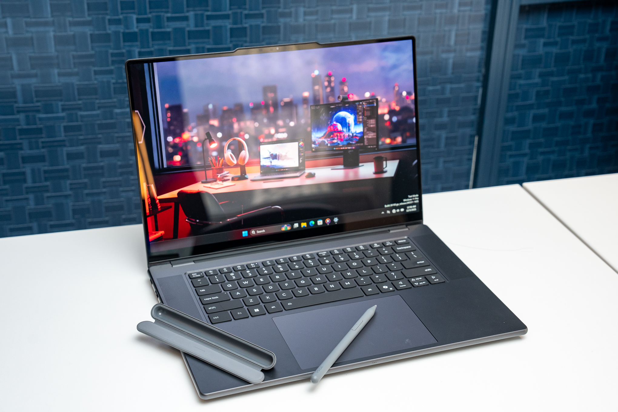 The Lenovo Yoga Pro 9i with its stylus and magnetic pen case resting on its keyboard deck.