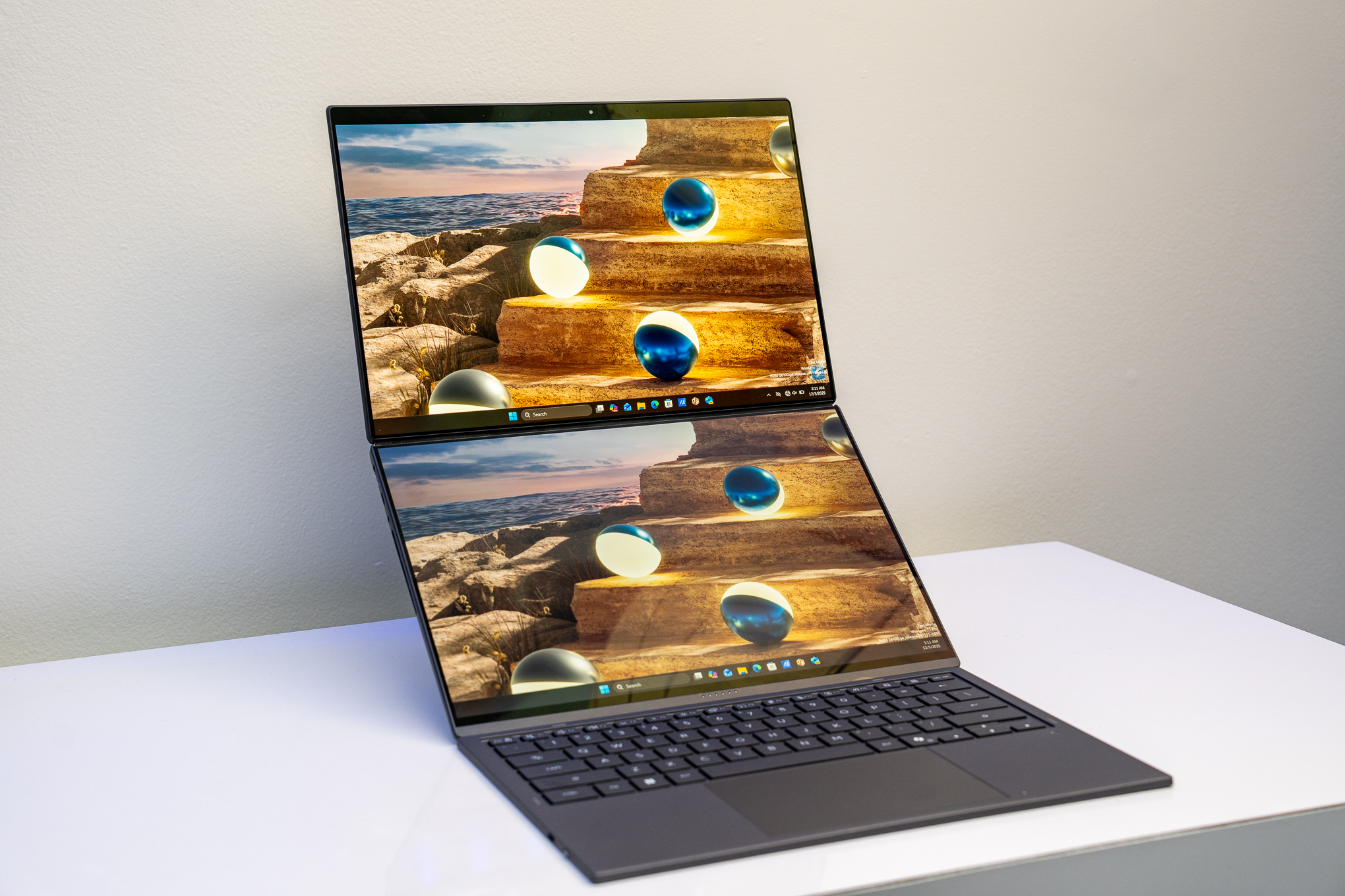 The 2026 Asus Zenbook Duo on a white table with its dual screens in top-and-bottom orientation and keyboard in front of it.