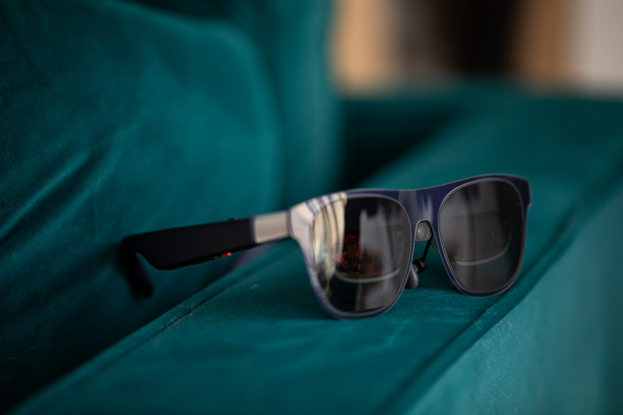 Close up of the Xreal 1S on a green velvet couch arm